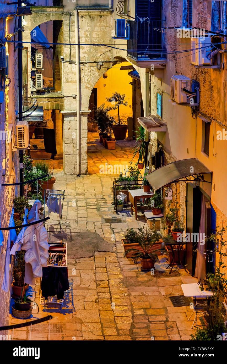 Nächtliche Szene einer Gasse in Bari Vecchia, beleuchtet von warmen und kühlen Lichtern. Italien. Stockfoto