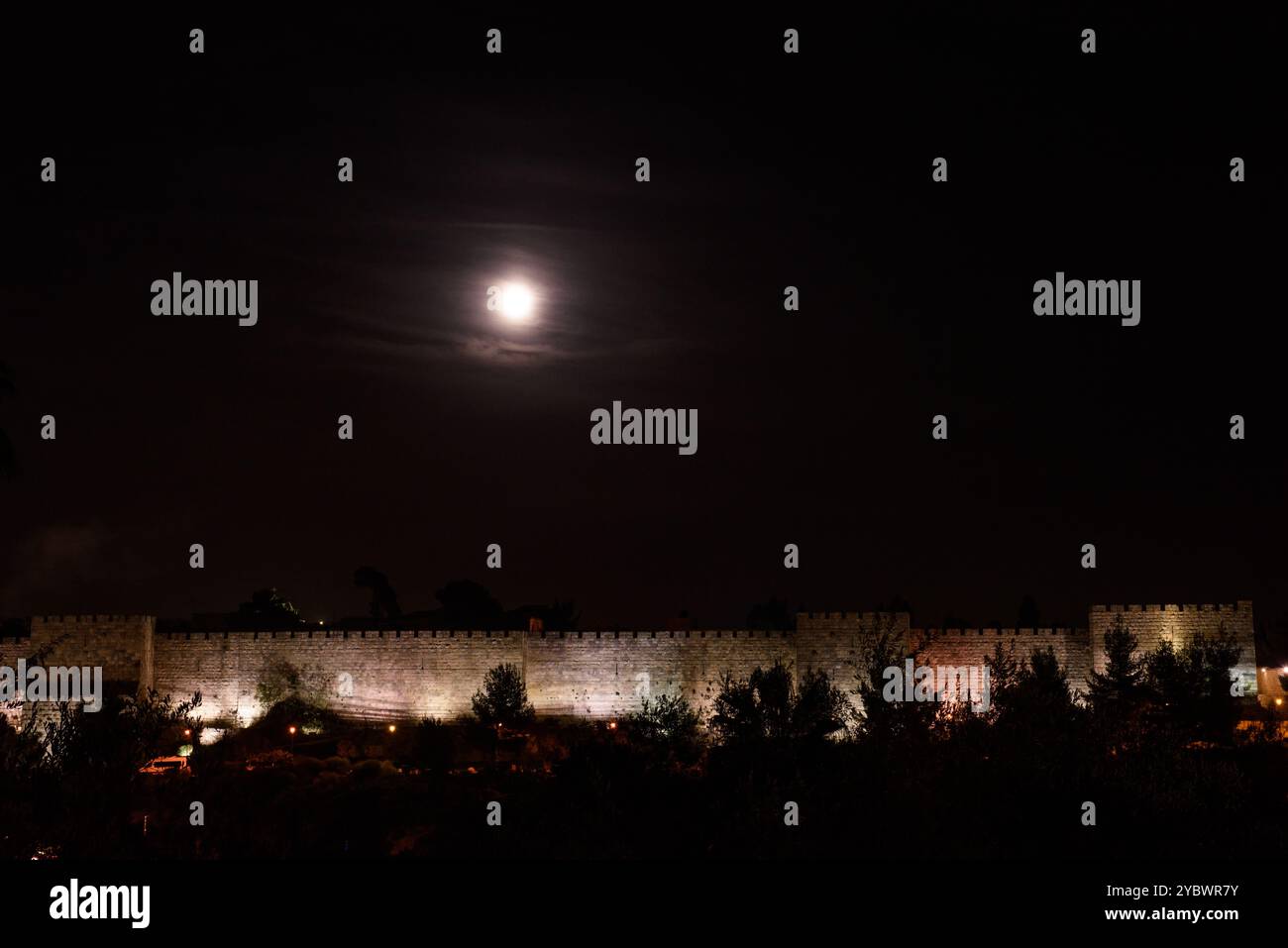 Der Vollmond erhebt sich hoch über einem Abschnitt der alten Mauern und Stadtmauern der Altstadt von Jerusalem, Israel. Stockfoto