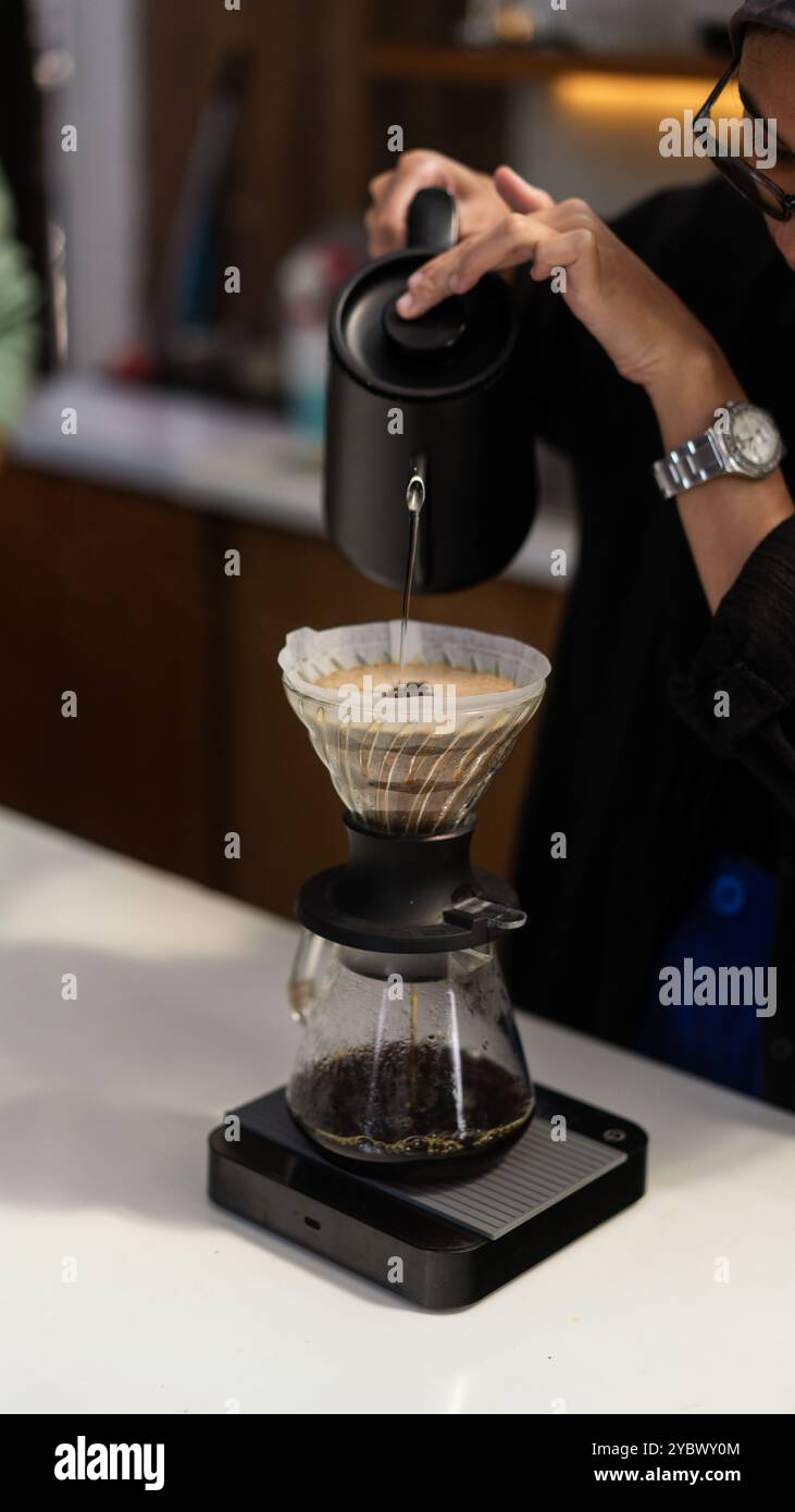 Der Barista bereite den heißen Kaffee mit der V60-Methode im Coffee Shop zu Stockfoto