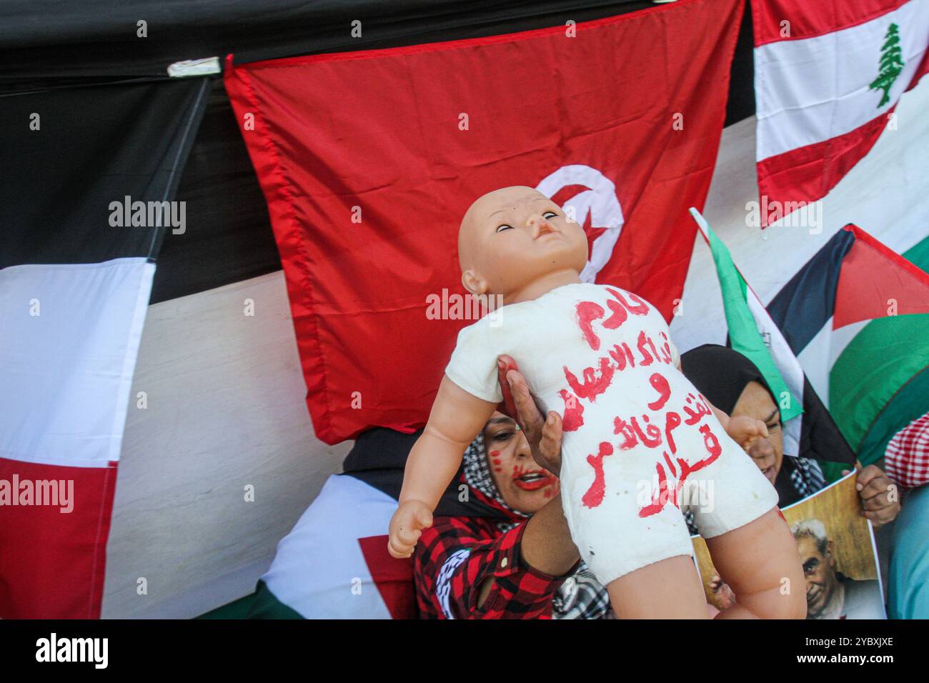 Tunis, Tunesien. 20. Oktober 2024. Babypuppen mit roten Flecken werden bei einem Protest in Tunis ausgestellt, um an die Kinder zu erinnern, die im Gazastreifen bei der laufenden israelischen Militäroffensive getötet wurden. Die Teilnehmer brachten Symbole und Banner zur Unterstützung des palästinensischen und des libanesischen Widerstands auf und schwenkten die palästinensische, libanesische, syrische und tunesische Flagge. Sie haben auch Bilder von Hamas- und Hisbollah-Führern aufgeworfen, die kürzlich von Israel ermordet wurden Stockfoto