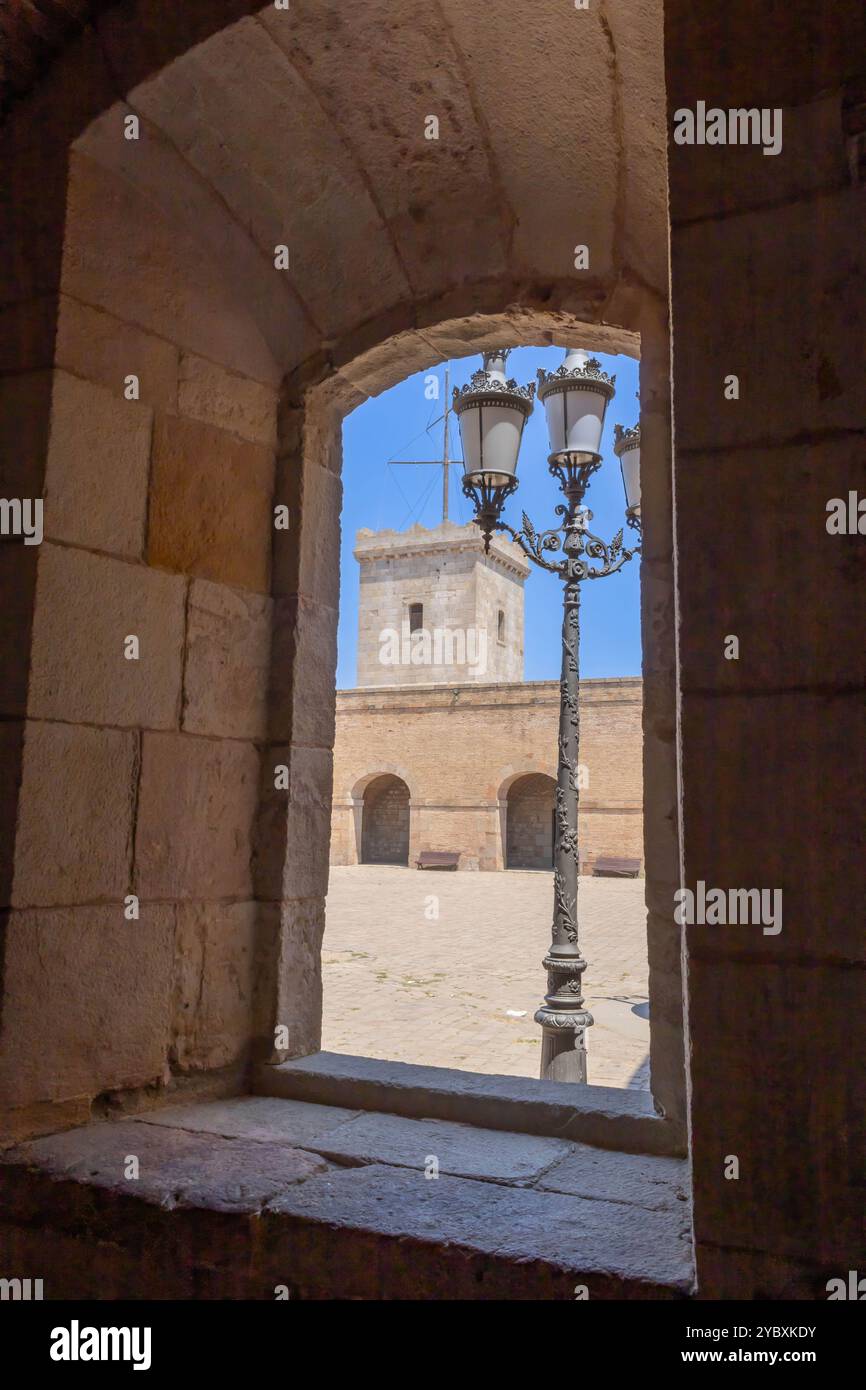 Ein Innenhof und Wachturm von Montjuic Castle, der durch das Arkadenfenster gesehen wird. Barcelona, Spanien Stockfoto