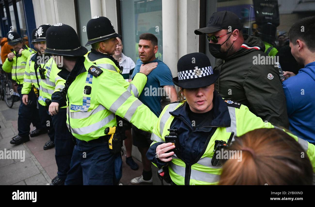 Brighton UK 7. August 2024 - Ein örtlicher Händler, der in der Nähe arbeitete, wird von den Protesten verwickelt und wird von der Polizei geschützt, da Antirassisten gegen die jüngsten rechtsextremen Demonstrationen in ganz Großbritannien protestieren . Seit der Ermordung von 3 Kindern in Southport im Juli gab es Rassenunruhen : Stockfoto