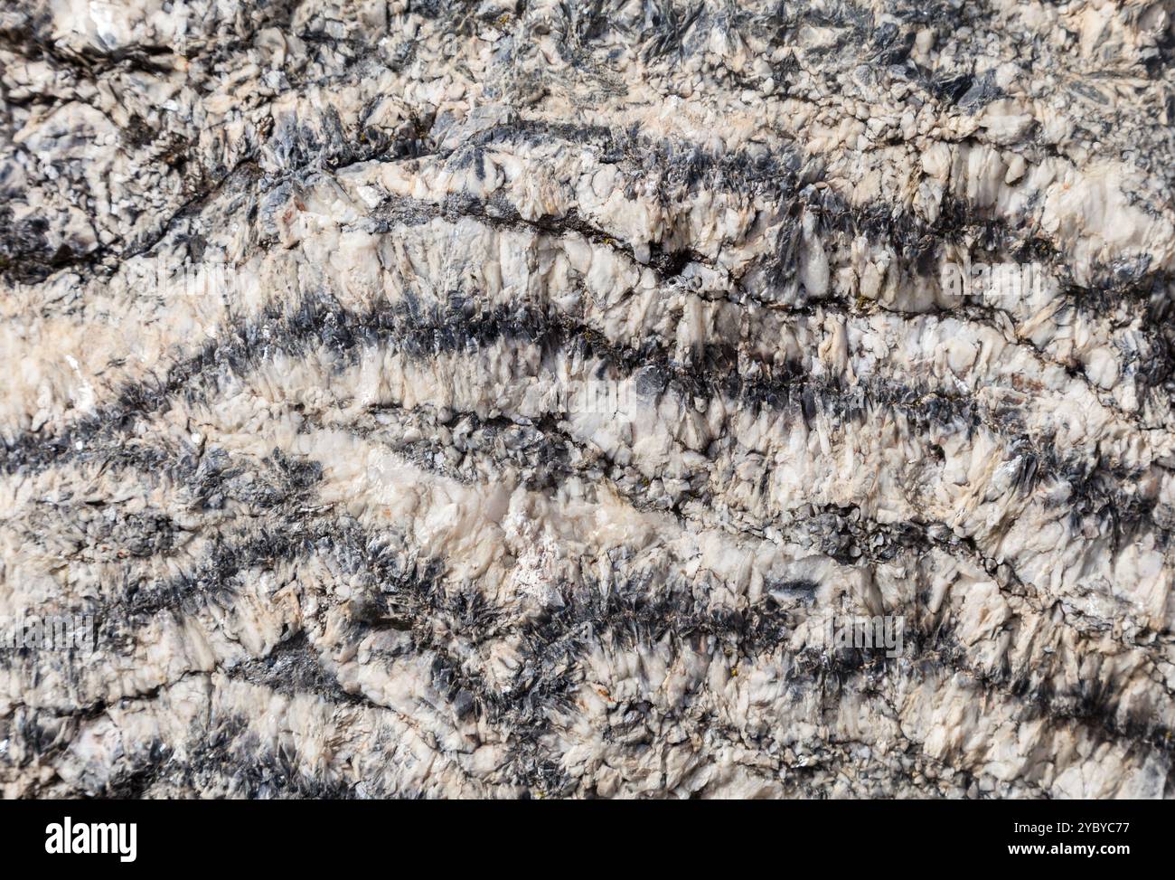 Einzigartige Mineralmuster zeigen markante Strukturen in Felsen, die von Sonnenlicht beleuchtet werden und die Kunstfertigkeit der Natur zum Ausdruck bringen. Stockfoto