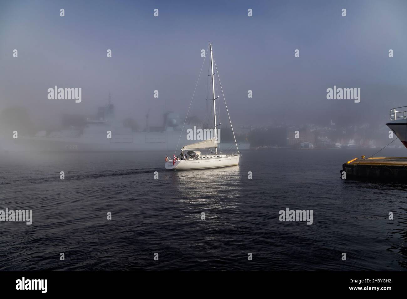 Segelboot erster Spieler im Hafen von Bergen, Norwegen. Ein Herbsttag mit dickem Nebel rund um den Hafen Stockfoto