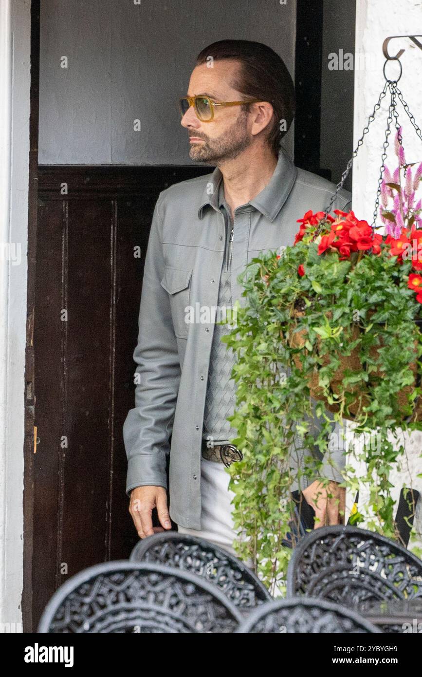 David Tennant am Set von Thursday Murder Club, der eine Szene im Red Lion Pub filmt, umgeben von Filmcrew und Ausrüstung. Der britische Schauspieler bereitet sich auf seine Rolle in der Verfilmung des Krimi-Dramas am historischen Ort vor und mischt filmisches Flair mit dem malerischen Charme der Kulisse. Stockfoto