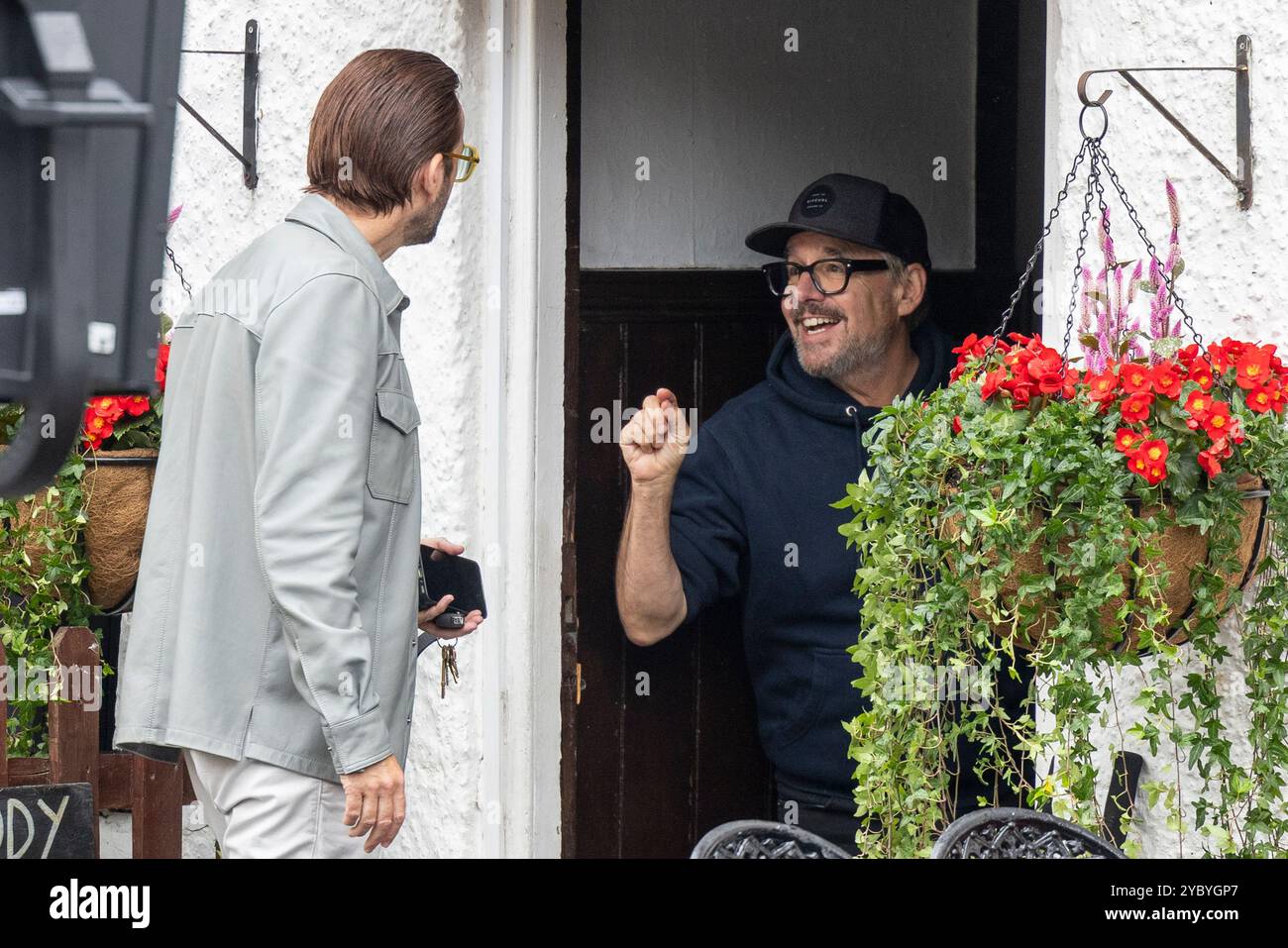 David Tennant am Set von Thursday Murder Club, der eine Szene im Red Lion Pub filmt, umgeben von Filmcrew und Ausrüstung. Der britische Schauspieler bereitet sich auf seine Rolle in der Verfilmung des Krimi-Dramas am historischen Ort vor und mischt filmisches Flair mit dem malerischen Charme der Kulisse. Stockfoto