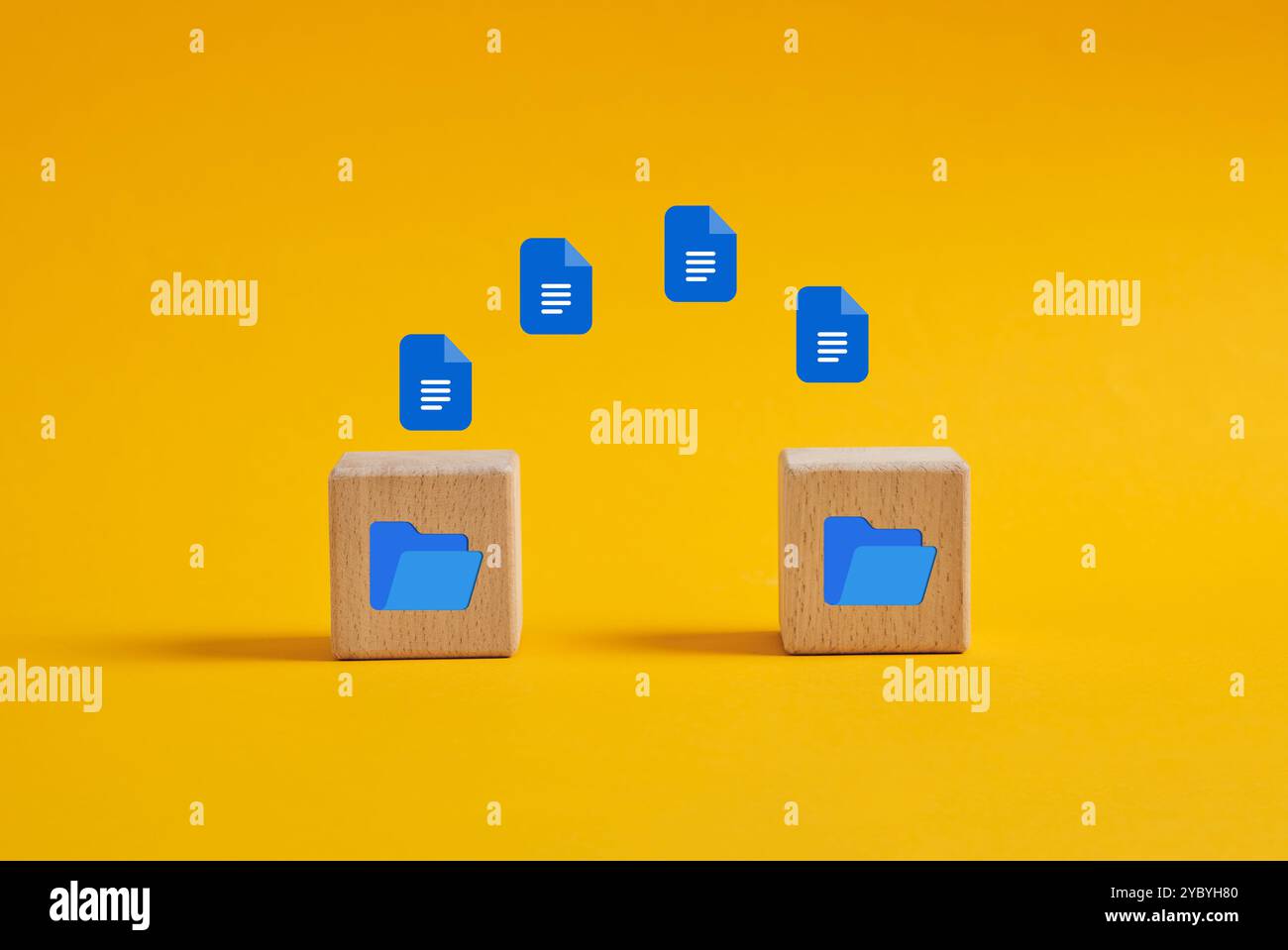 Daten- oder Dateiübertragungsprozess zwischen Ordnern. Dokumentsymbole, die in einen digitalen Ordner auf Holzwürfeln auf gelbem Hintergrund fliegen. Stockfoto