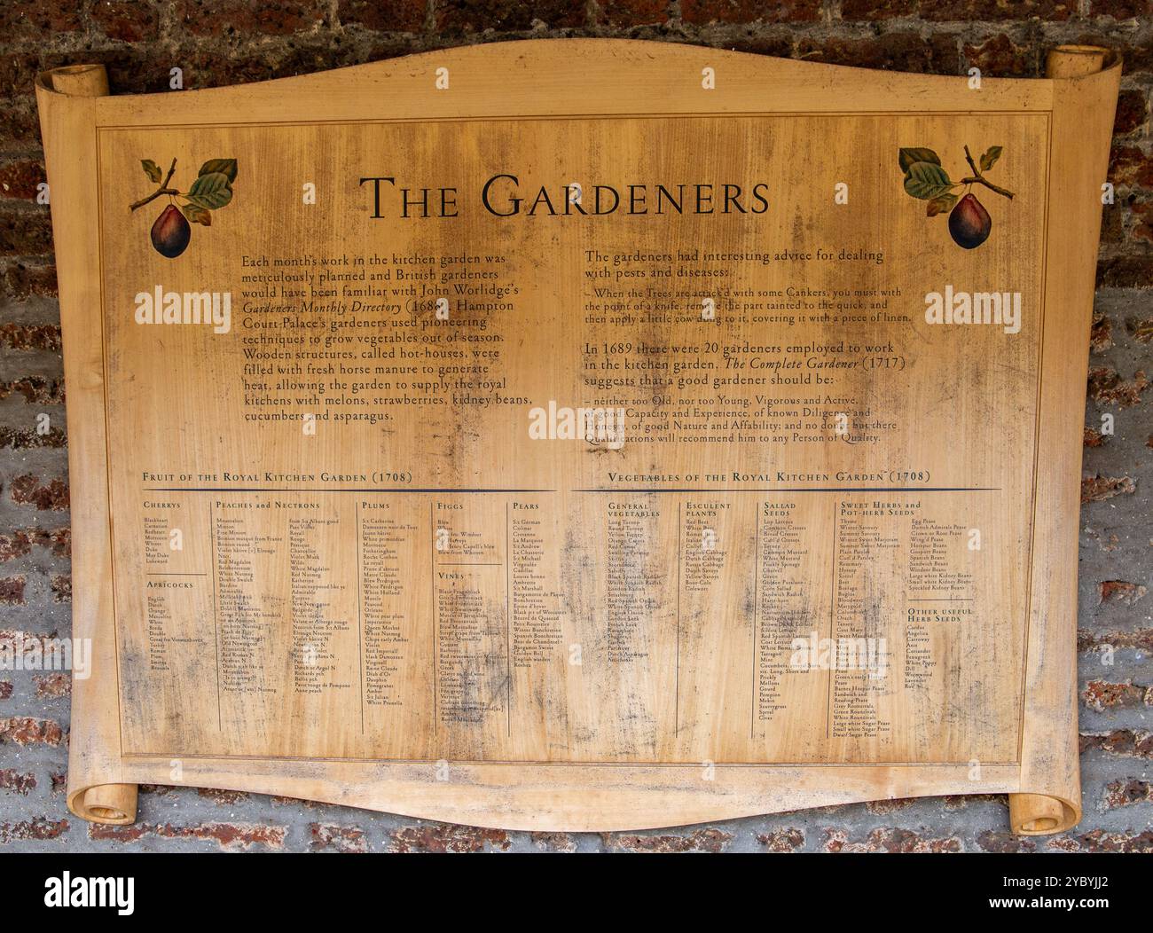Eine antike Tafel mit einer Liste von Gärtnern mit dekorativen Elementen an einer freiliegenden Ziegelwand Stockfoto