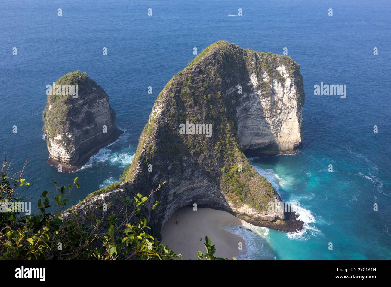 Von oben krachen türkisfarbene Wellen sanft auf den weichen Sand von Kelingking Beach in Nusa Penida, Bali. Die hellen Farben zeigen die Schönheit und Ruhe Stockfoto