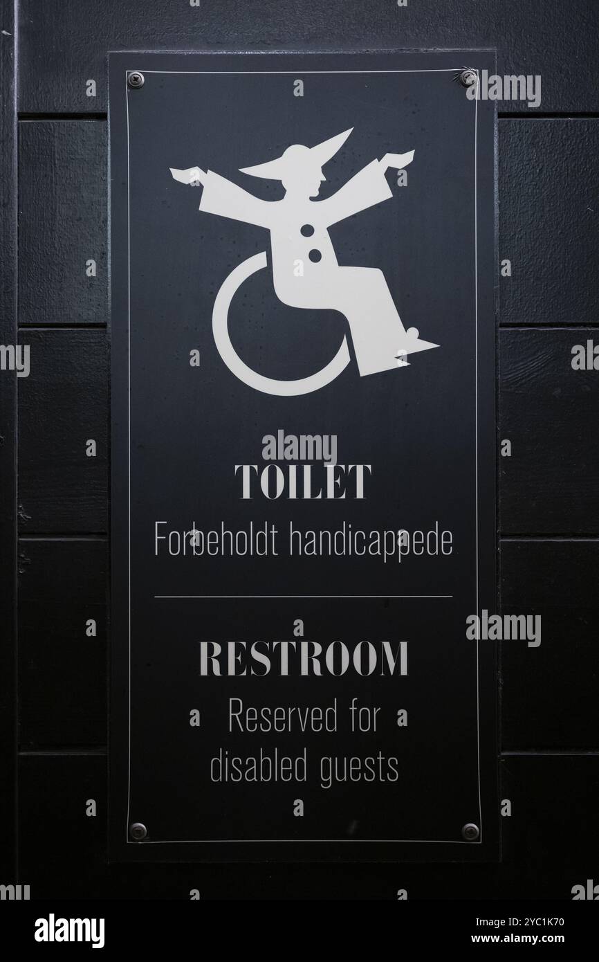 Schild für Behindertentoilette mit Rollstuhlsymbol auf schwarzem Hintergrund, Tivoli Amusement and Recreation Park, Kopenhagen, Dänemark, Europa Stockfoto