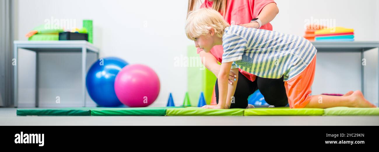 Junge beim Training mit Physiotherapeutin während der Therapiesitzung. Ergoskopische Therapie des Kindes. Bilaterale Koordinierung. Stockfoto