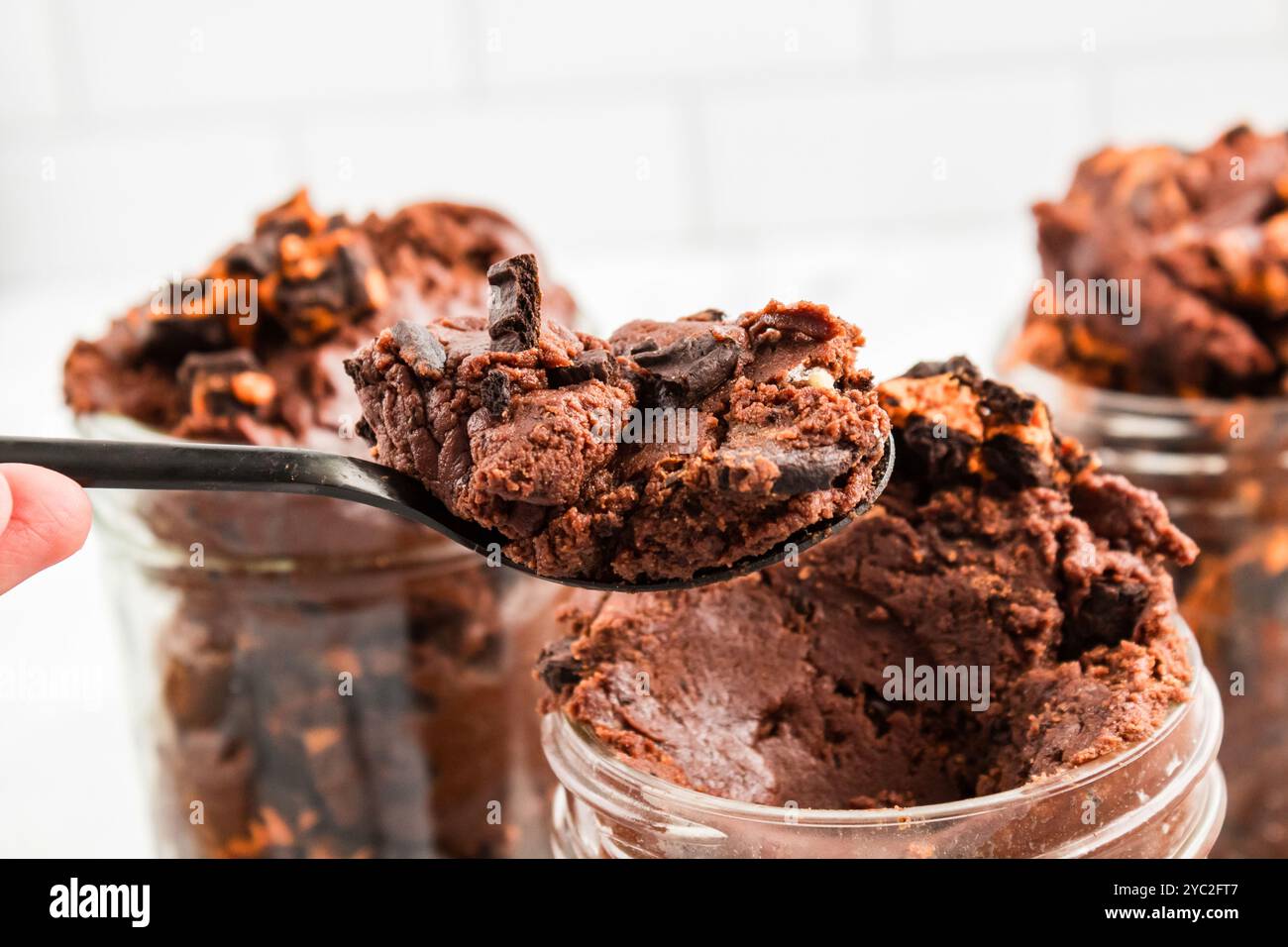 Nicht gebackener Brownie-Teig mit Halloween-Keksen in einem Glas Stockfoto