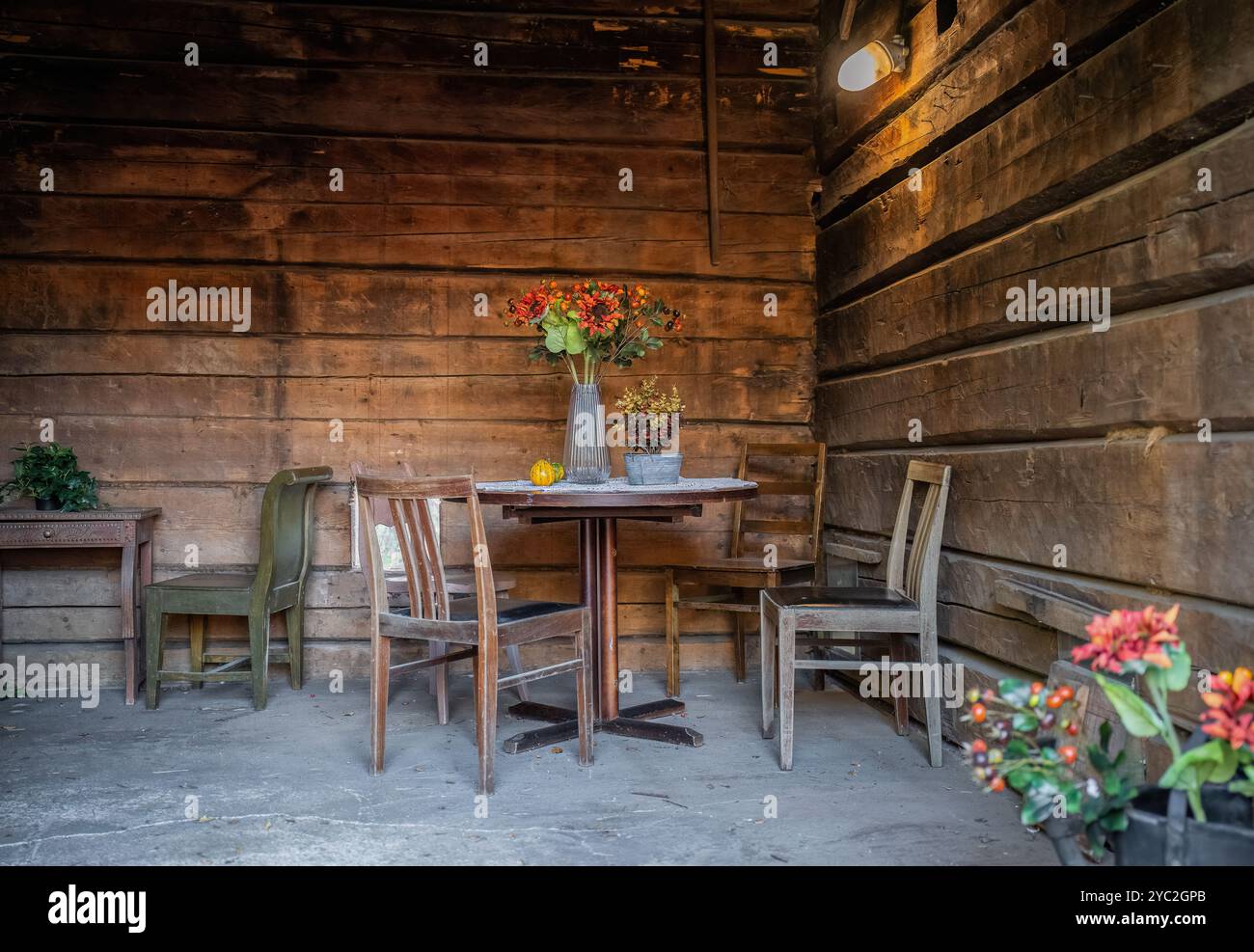 Alte Holzstühle und ein mit Staub bedeckter Tisch in einer Holzeinrichtung Stockfoto