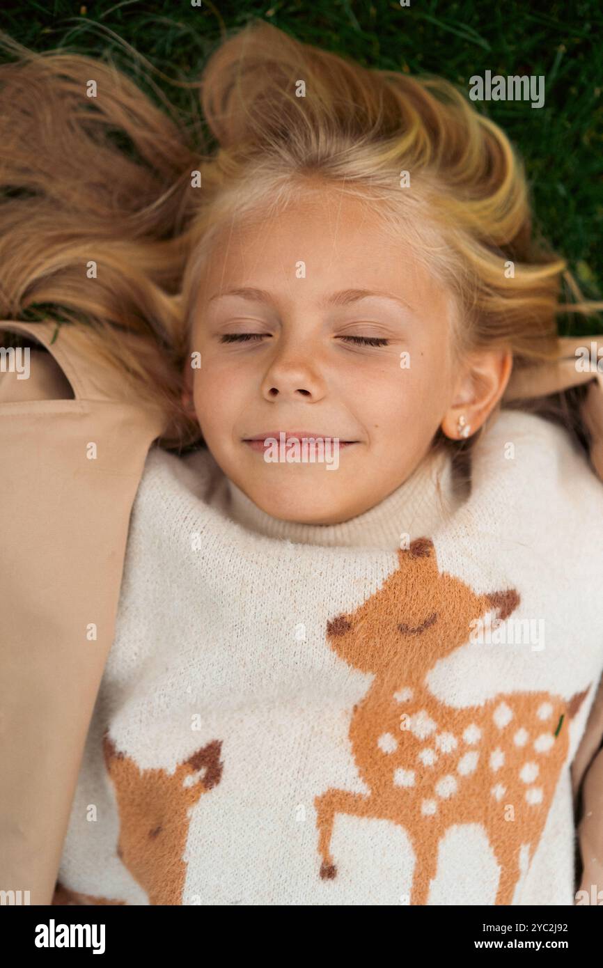 Das Mädchen liegt auf dem grünen Gras Stockfoto