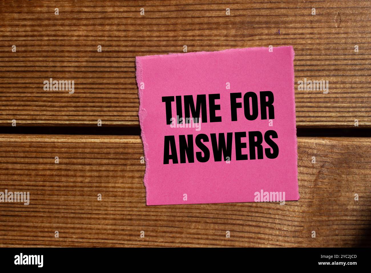 Zeit für Antworten Nachricht geschrieben auf gerissenem rosafarbenem Papierstück mit hölzernem Hintergrund. Symbol für die konzeptionelle Zeit für Antworten. Kopierbereich. Stockfoto