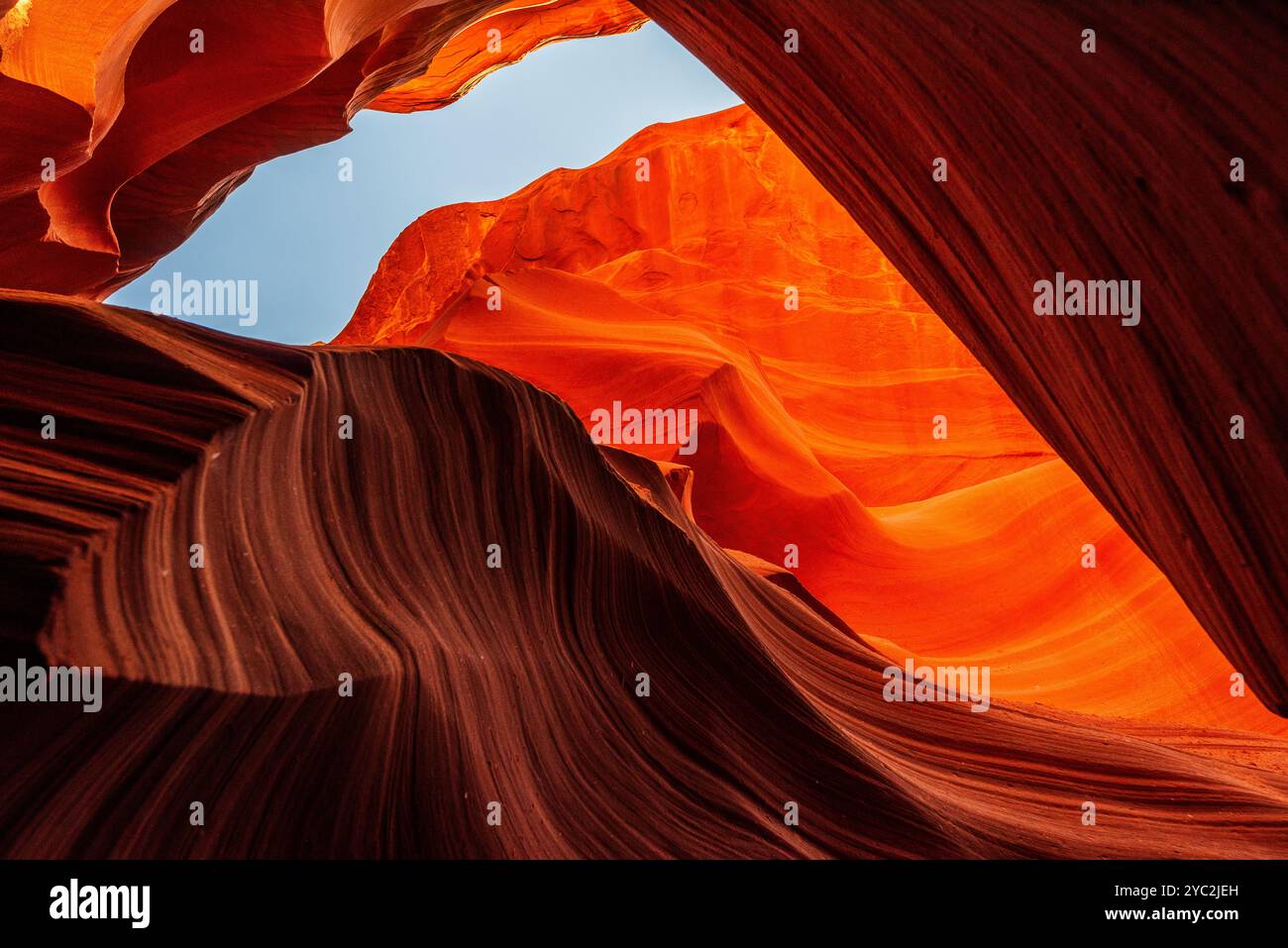 Blauer Himmel umrahmt von rot-orangen Sandsteinkurven des Antelope Canyon. Stockfoto
