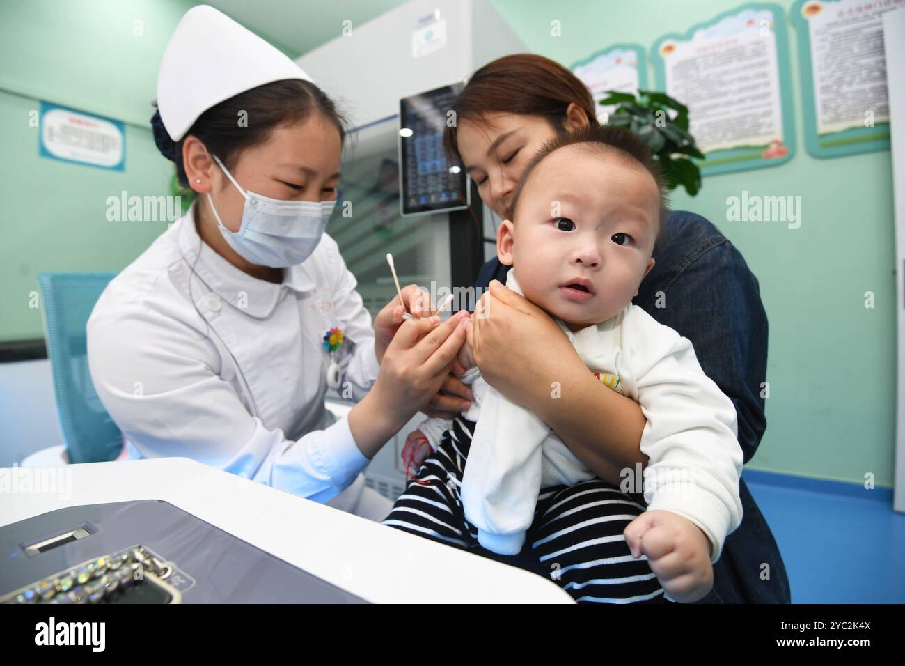 GUIYANG, CHINA - 21. OKTOBER 2024 - Ein Gesundheitspersonal geimpft Säuglinge gegen Haemophilus influenzae Typ B beim ersten Gemeindegesundheitsdienst Stockfoto