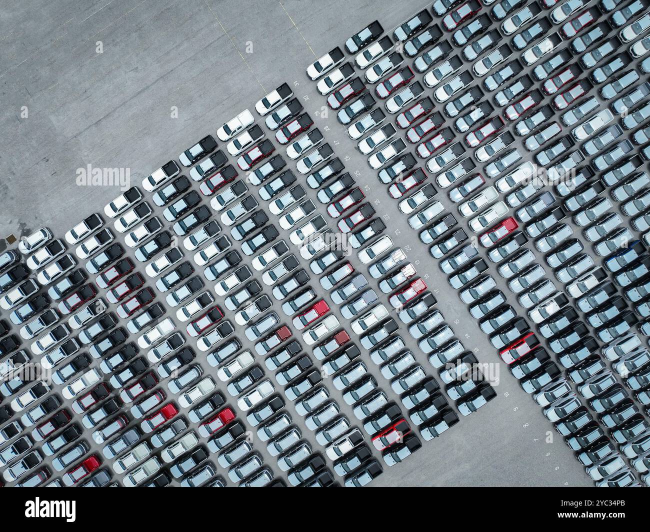 Luftaufnahme des Bestands neuer Autos auf einem großen Fabrikparkplatz. Automobilindustrie, Logistikbetrieb und Fahrzeuglagerung für Import und Export. Stockfoto