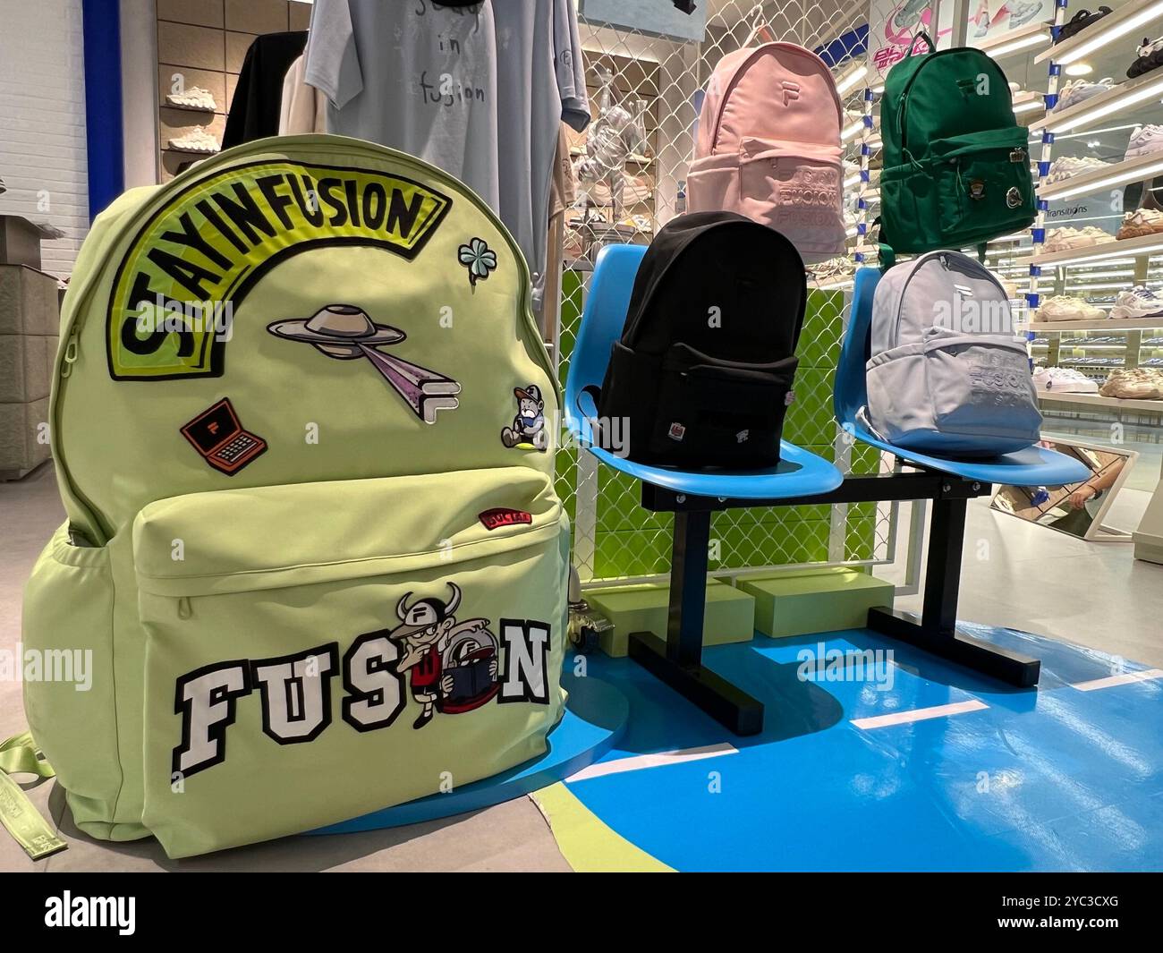 Riesige Fila-Markenbeutelpackung auf markantem Display und andere kleinere Taschen in verschiedenen Farben im Lifestyle-Shop im Einzelhandel. - Smartphone-aufgenommenes Stockfoto