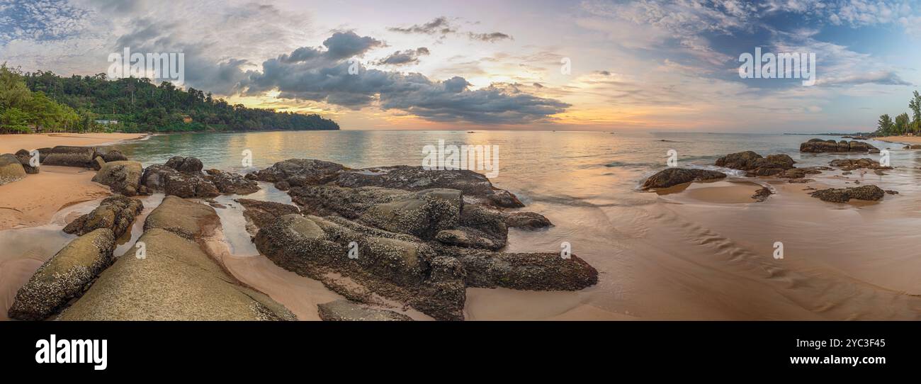 Tropischer Strand Sonnenuntergang mit Felsküste und Meereswelle am Khao Lak, Phang Nga Thailand Naturlandschaftspanorama Stockfoto