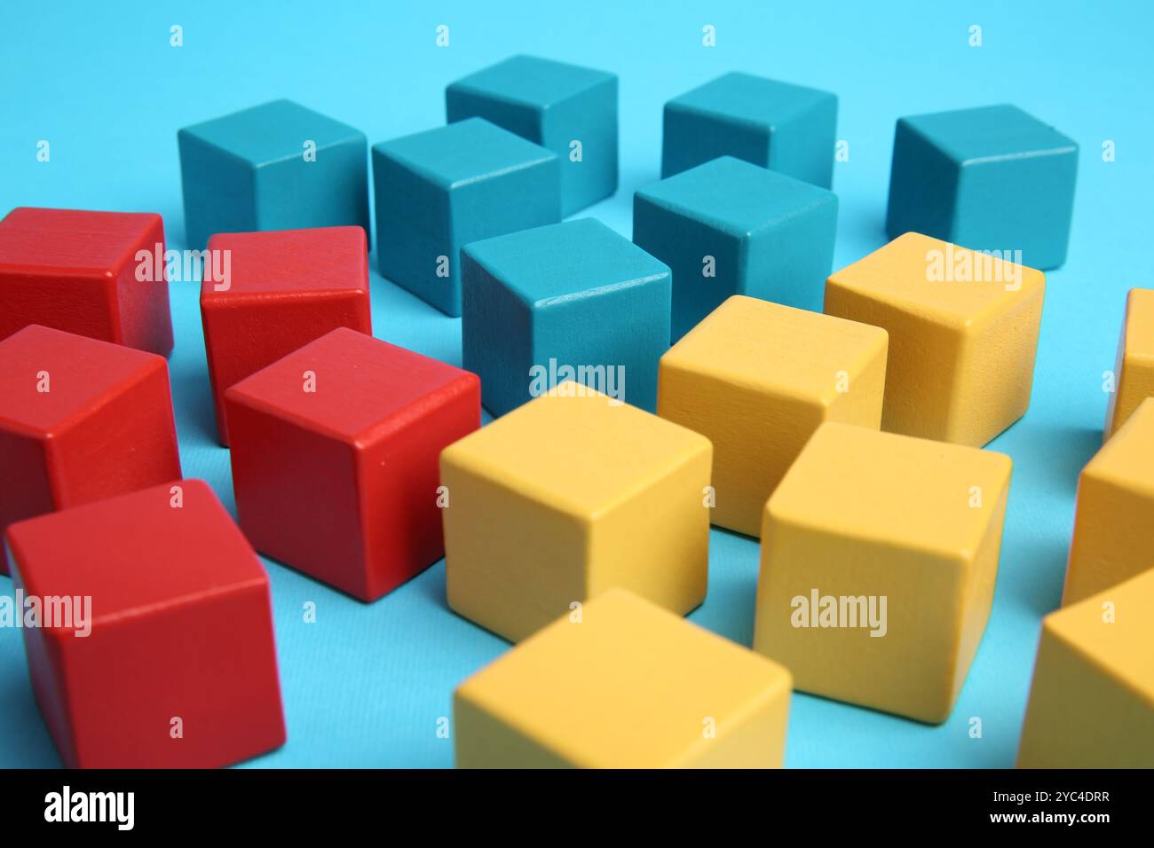 Viele bunte Würfel auf hellblauem Hintergrund Stockfoto