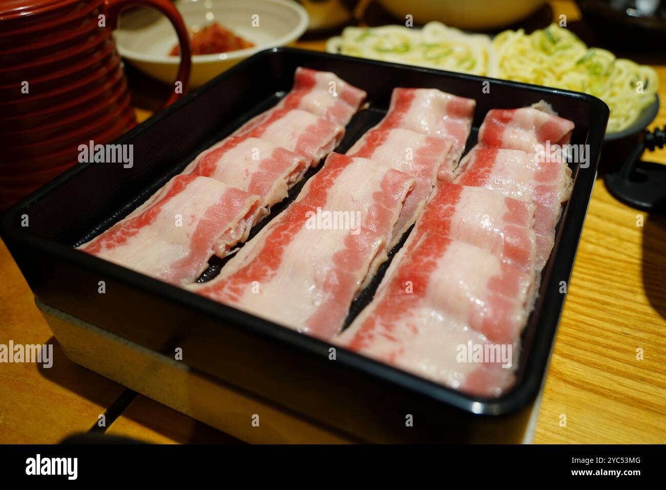 Roher Schweinebauch auf schwarzem Teller für japanische Gerichte. Stockfoto