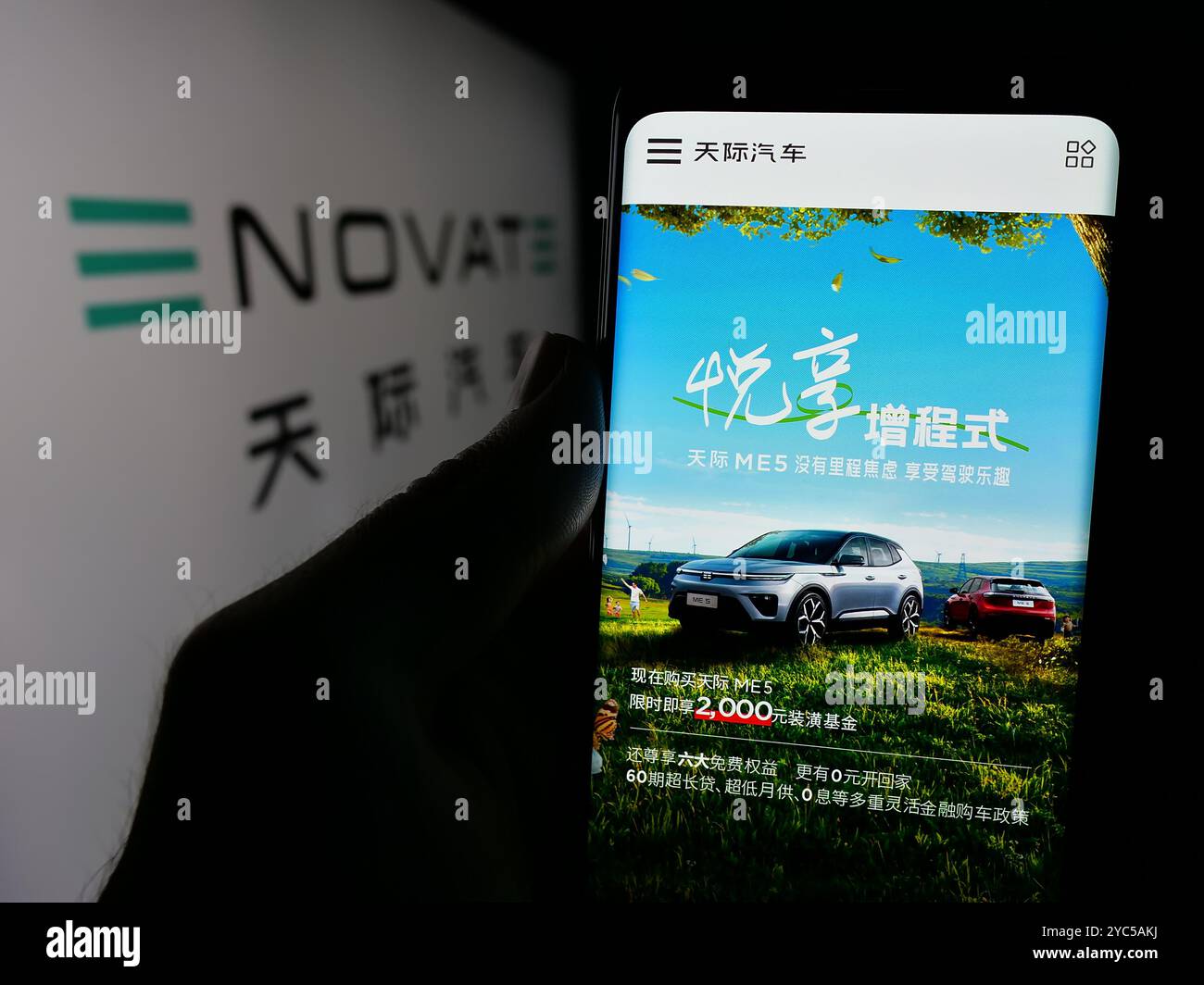 Person, die ein Smartphone hält, mit der Webseite des chinesischen Elektroautos Enovate Motors auf dem Bildschirm mit Logo. Konzentrieren Sie sich auf die Mitte des Telefondisplays. Stockfoto