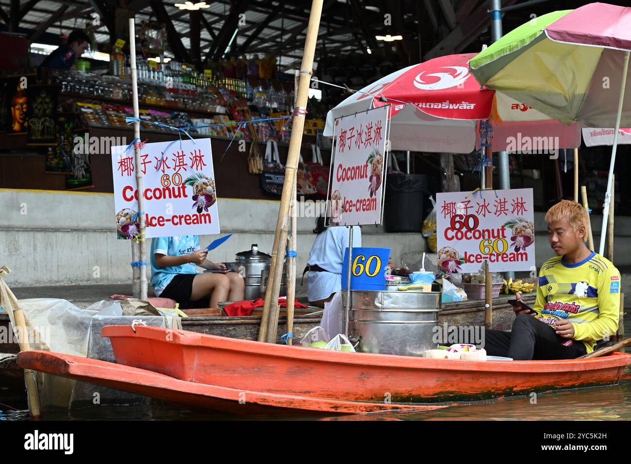 'Schwimmender Markt Thailand' Einheimische in Thailand verkaufen Kokos-Eis im Boot unter dem Schatten des Schirms in Damneon Saduak Thailand Bang Stockfoto