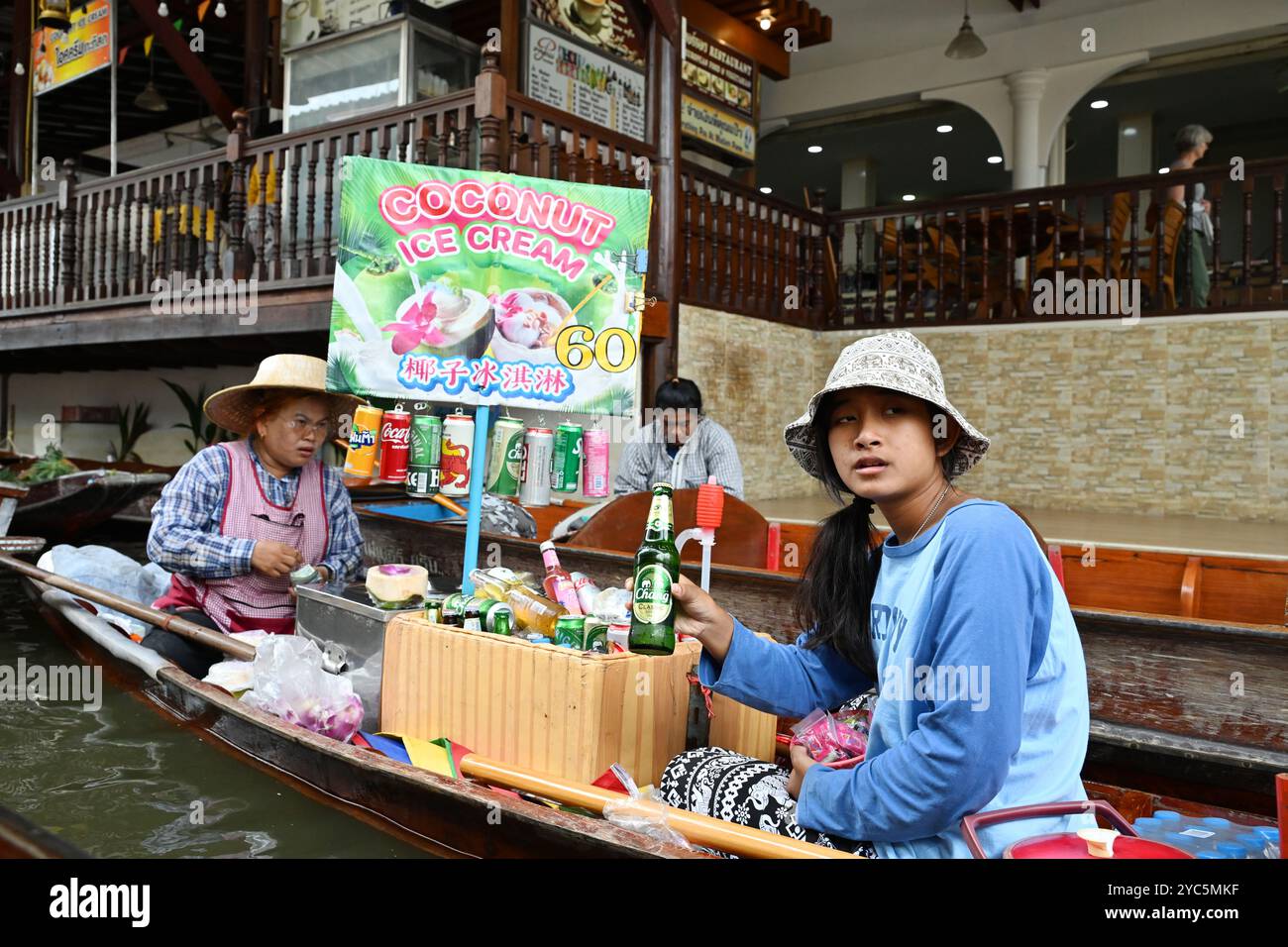 „Floating Market Thailand“-Porträt von einheimischen Frauen in Thailand, die Kokos-Eis in einem Boot durch den belebten Kanal im Damneon saduak Bangkok verkaufen Stockfoto