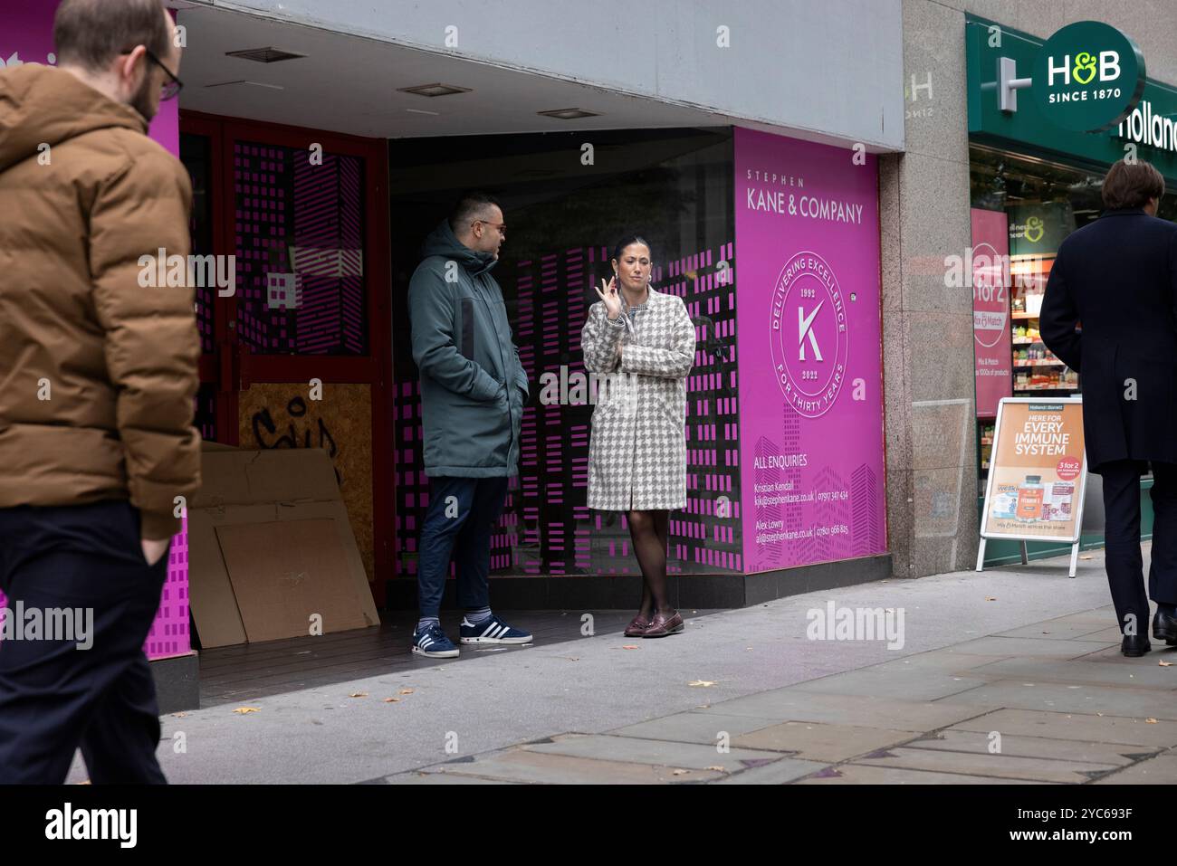 Arbeiter, die im Eingang eines geschlossenen Einzelhandelsgeschäfts in Cheapside in der City of London, England, Großbritannien, dampfen Stockfoto