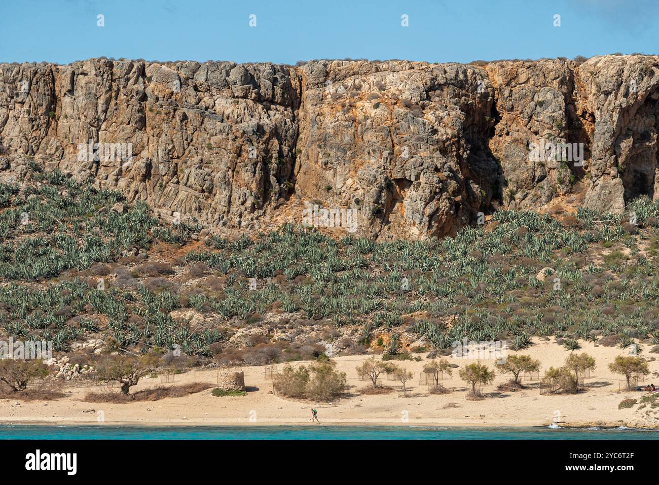 Ugged Cliffs and Scenic Beach in Gramvousa, Kreta die hoch aufragenden Klippen der Insel Gramvousa erheben sich dramatisch über dem abgelegenen Strand und schaffen einen Stockfoto