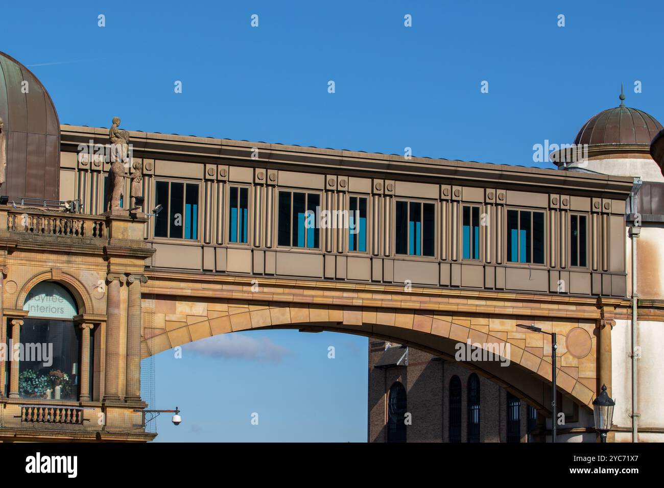 Eine dekorative Brücke mit modernem architektonischem Design aus der Nähe. Die Brücke verfügt über große Fenster und wird von einer kunstvollen Steinstruktur gestützt Stockfoto