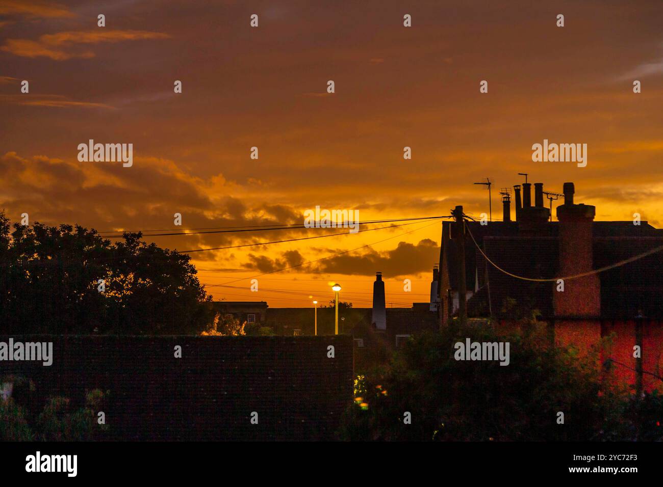 Northampton, Großbritannien 21. Oktober 2024. Wetter. Farbenfroher Abschluss des Tages mit Blick über die Dächer bei einem goldenen Sonnenuntergang nach einem grauen Tag. Quelle: Keith J Smith./Alamy Live News Stockfoto