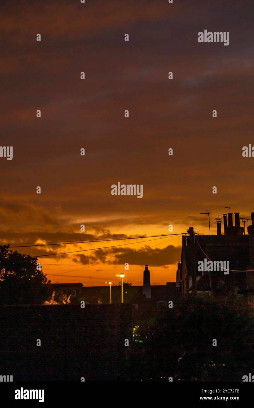 Northampton, Großbritannien 21. Oktober 2024. Wetter. Farbenfroher Abschluss des Tages mit Blick über die Dächer bei einem goldenen Sonnenuntergang nach einem grauen Tag. Quelle: Keith J Smith./Alamy Live News Stockfoto
