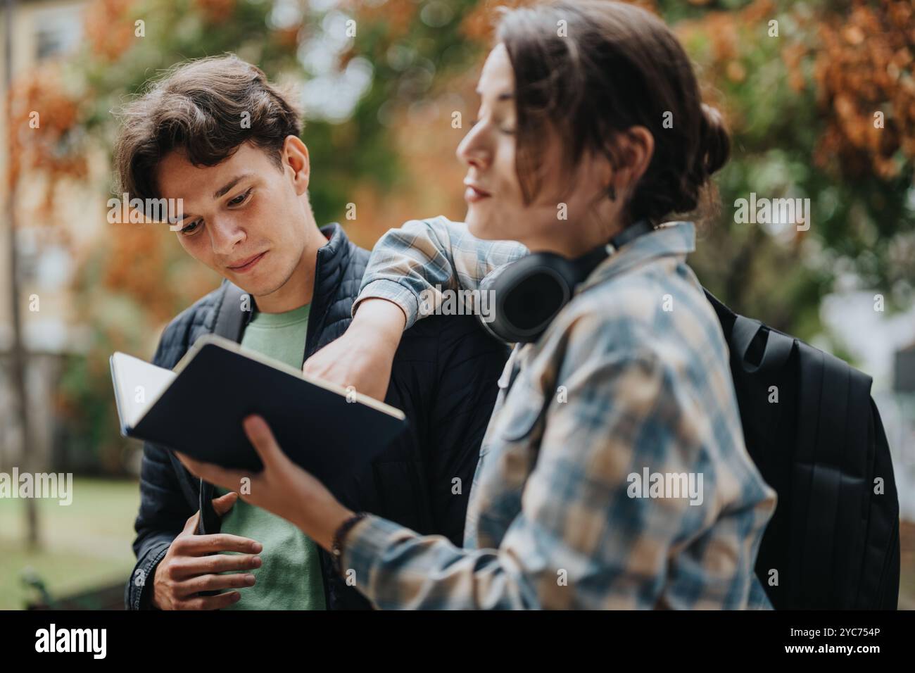 Zwei Schüler studieren gemeinsam im Freien mit einem Notizbuch Stockfoto