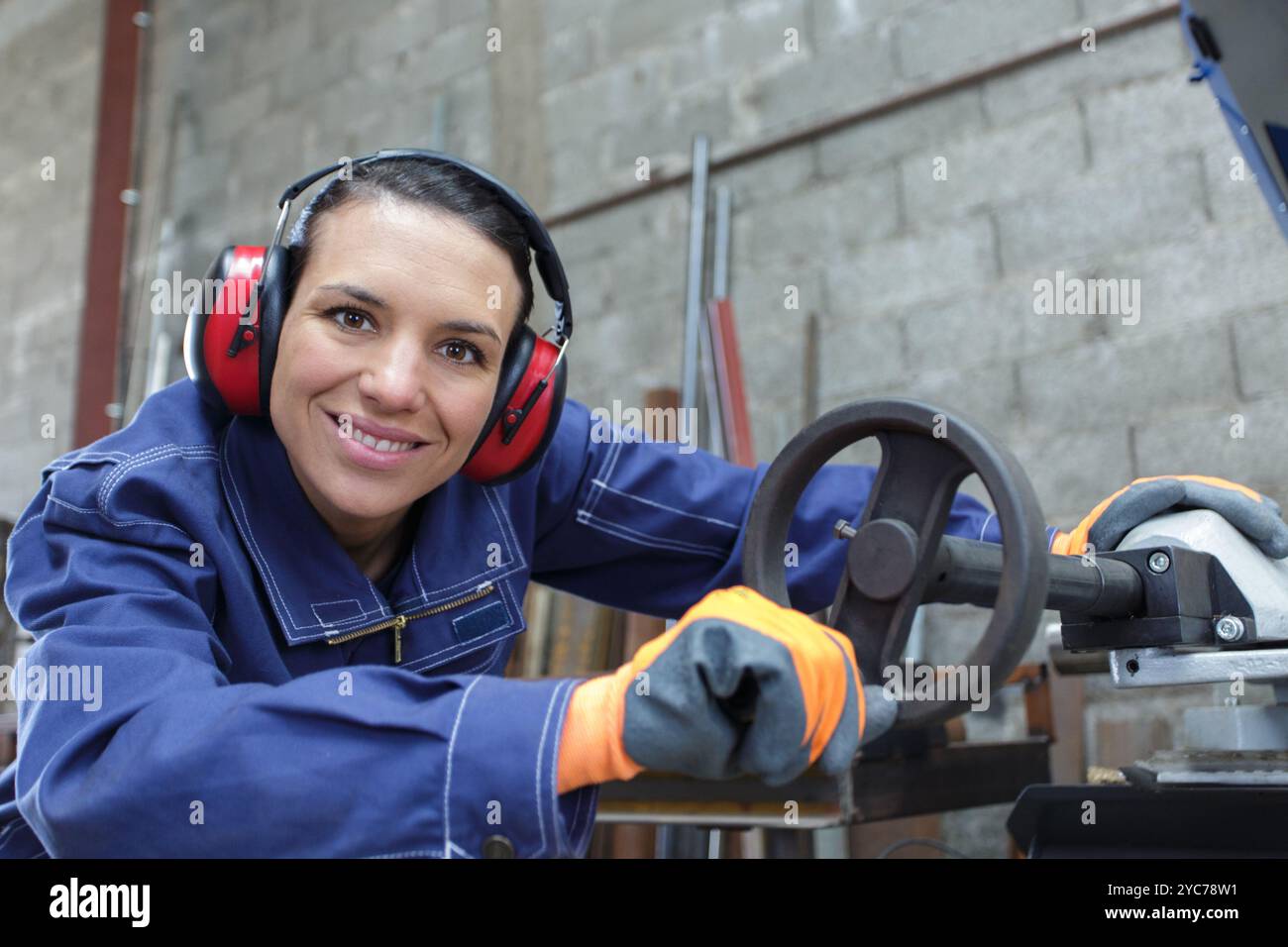 Frau in Werkstatt mit Noise Cancelling-Kopfhörern Stockfoto