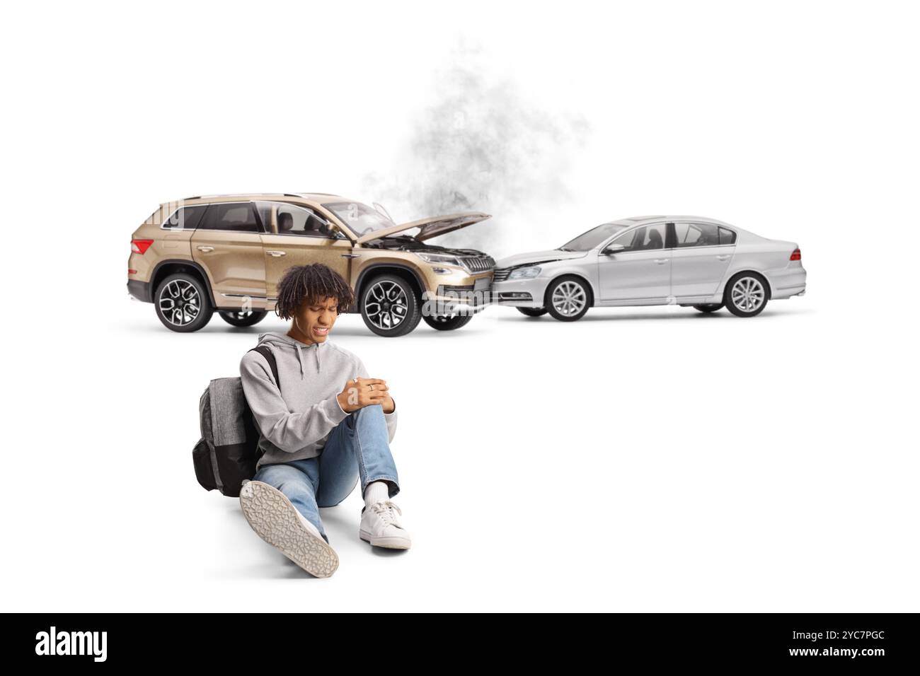 afroamerikanischer Student, der auf dem Boden sitzt, mit einem verletzten Knie von einer Autokollision isoliert auf weißem Hintergrund Stockfoto