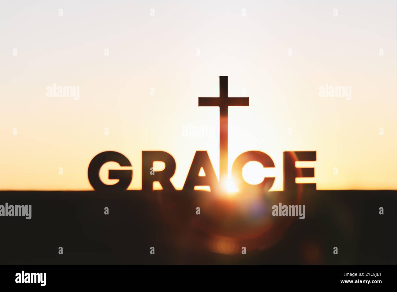 Heller aufgehender Sonnenaufgang im neuen Jahr, schönes Sonnenlicht und heiliges Kreuz von jesus christus, Gnadenwort GNADE Hintergrund Stockfoto