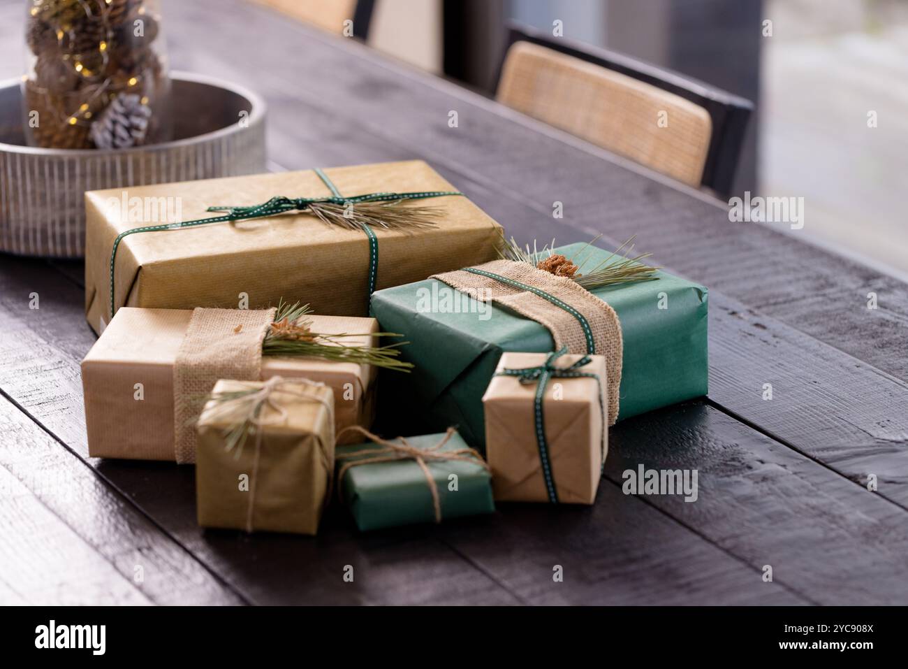 Weihnachtsgeschenke in Naturpapier und Bänder auf Holztisch, zu Hause Stockfoto