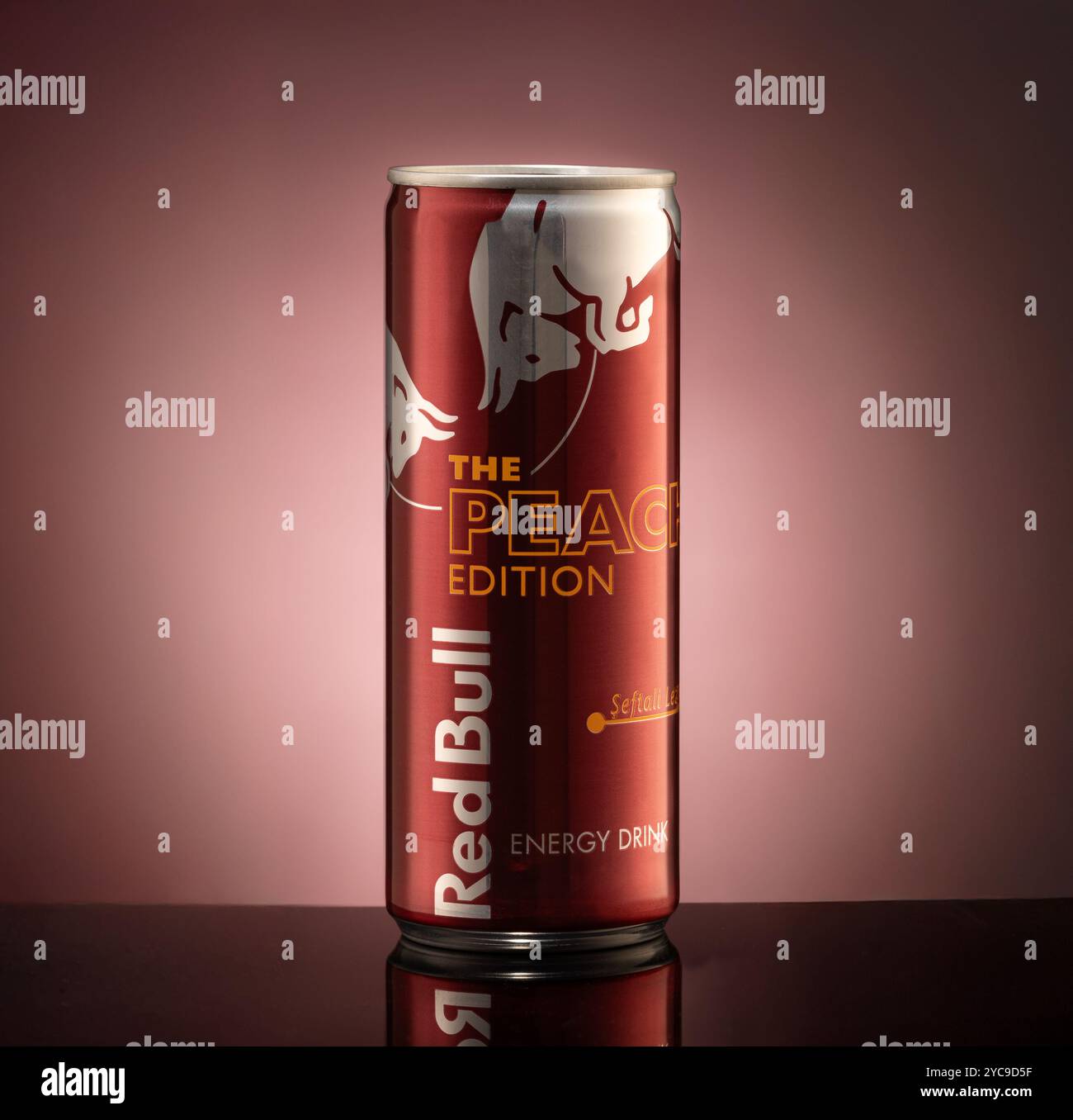 Istanbul, Türkei - 20. Oktober 2024: Nahaufnahme der Redbull Peach Edition kann auf schwarzer reflektierender Oberfläche isoliert werden Stockfoto