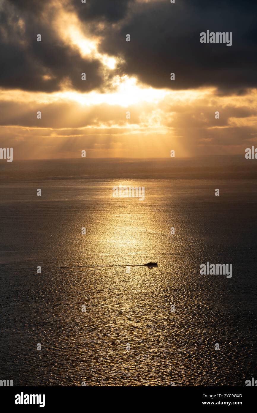 Abendsonne am Rande der Bucht von Arcachon (Südwestfrankreich): Licht zwischen Wolken am Abend vor Sonnenuntergang und Bootssegeln in aller Ruhe Stockfoto