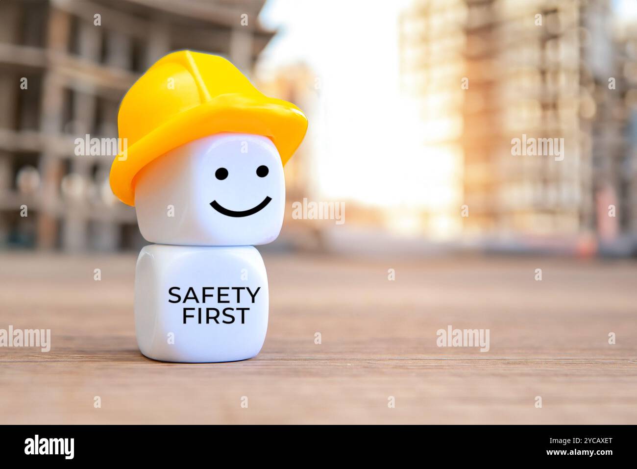 Weiße Würfel mit Schutzhelm und TEXTSICHERHEIT ZUERST. Kopierbereich für Text. Stockfoto