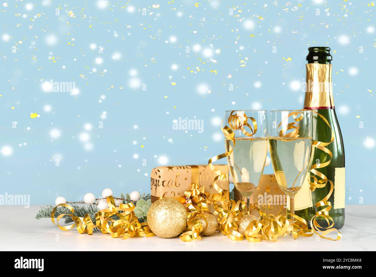 Flasche Champagner mit Kristallgläsern, goldenen weihnachtskugeln und weihnachtsgeschenkboxen auf einem weißen Tisch. Silvesterfeier Konzept Backgrou Stockfoto