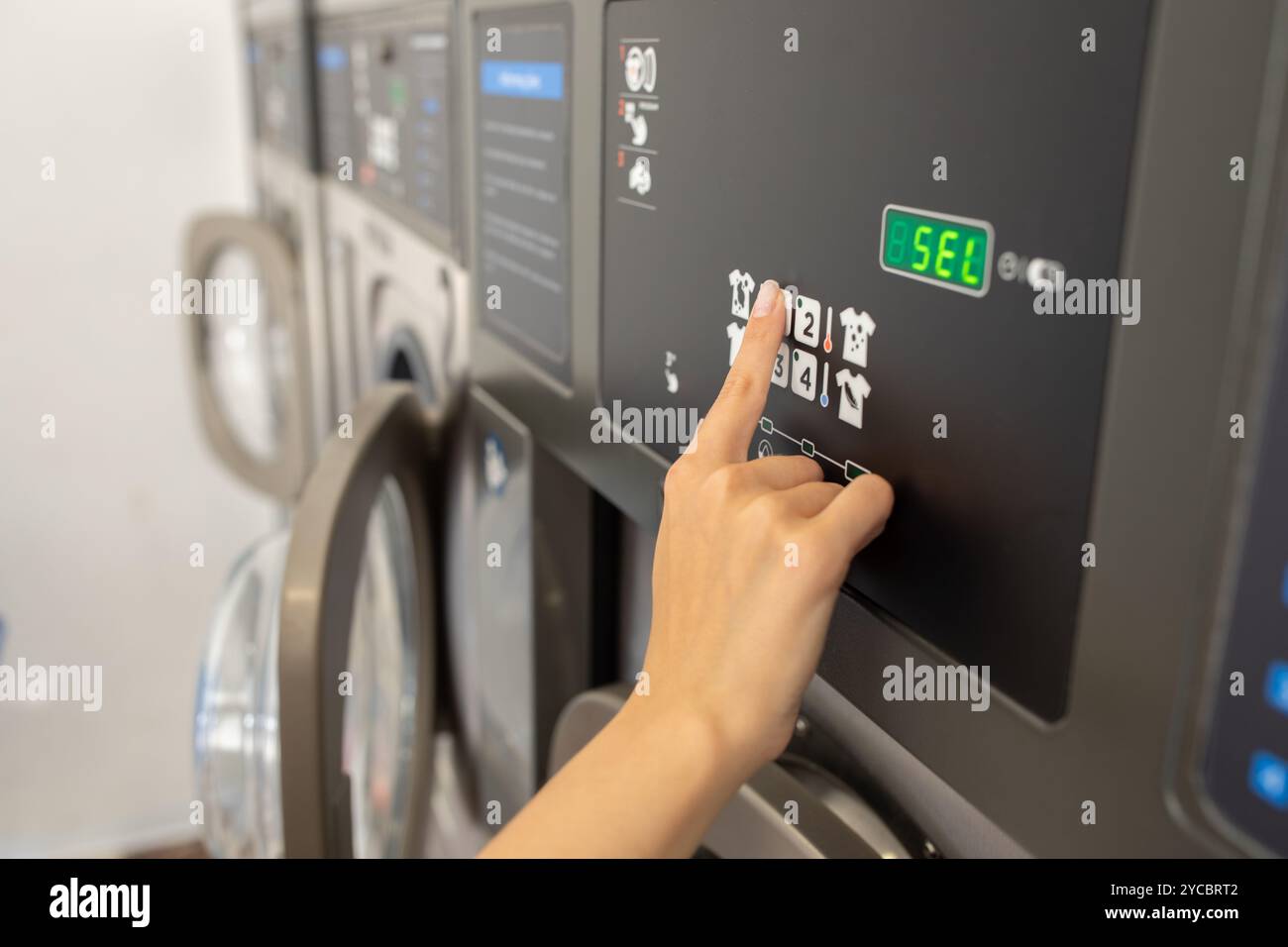 Verwenden einer Waschmaschine zur schnellen Reinigung in einem Waschsalon Stockfoto