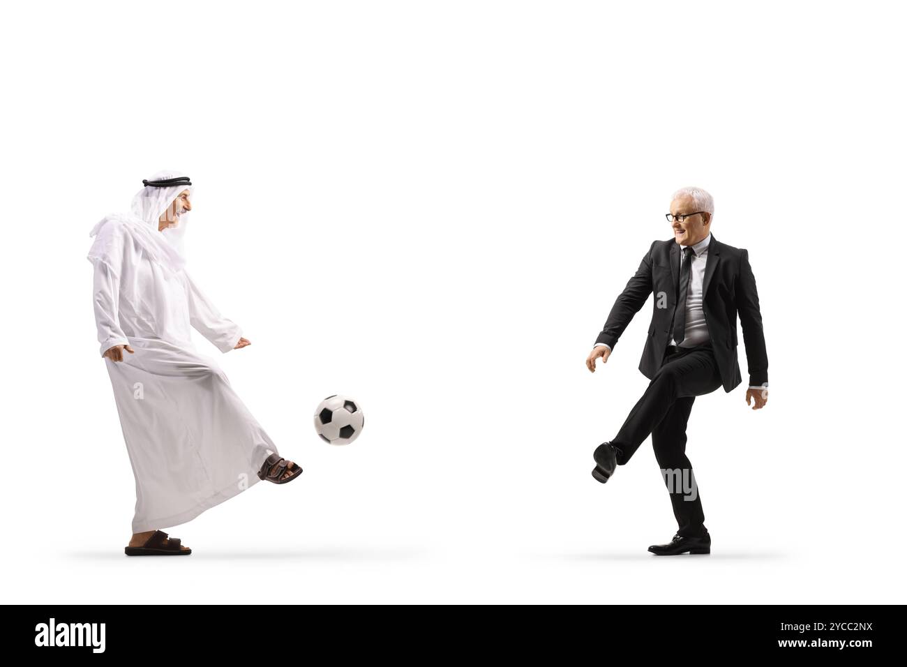 Arabischer Mann in ethnischer Kleidung, der mit einem Geschäftsmann auf weißem Hintergrund Fußball spielt Stockfoto