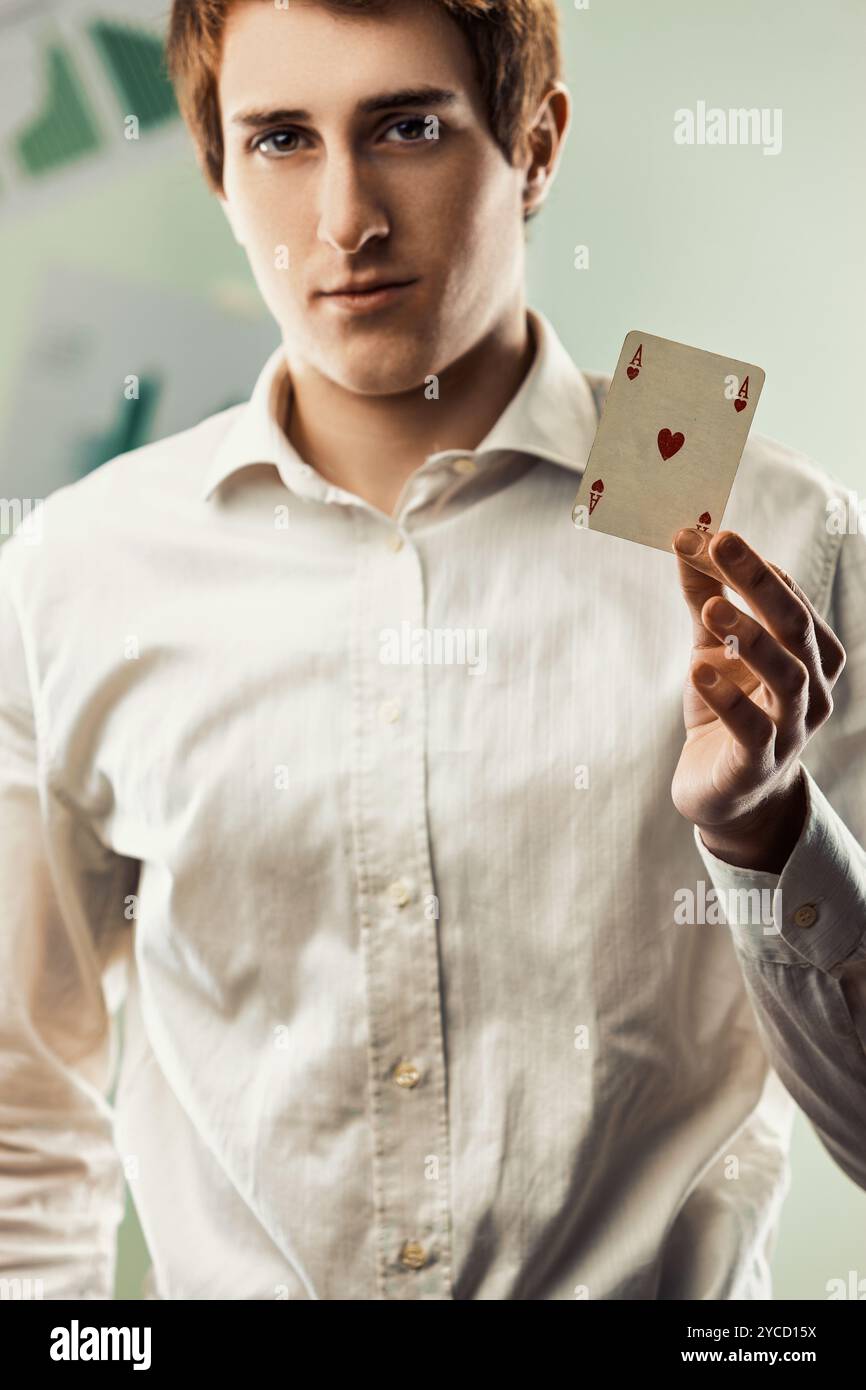 Der Geschäftsmann zeigt das Herz-Ass, das in seinem Büro steht. Dieses Bild kann verwendet werden, um Konzepte wie Business, Strategie und darzustellen Stockfoto