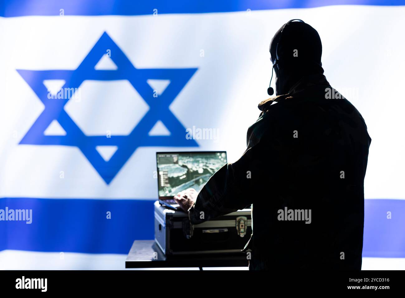 Mossad-Agent analysiert Überwachungsdaten während des globalen Krieges, isoliert über dem Hintergrund der israelischen Flagge. Der Geheimdienst beendet die Mission während der geopolitischen Operation des 3. Weltkriegs Stockfoto