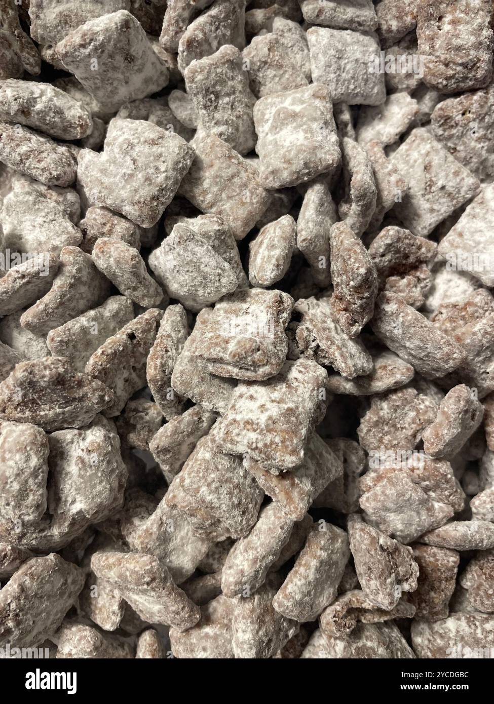 Nahaufnahme von hausgemachtem Puppy Chow Snack Mix, Schokolade, Erdnussbutter und Müsli mit Puderzucker überzogen. - Smartphone-aufgenommenes Stockfoto