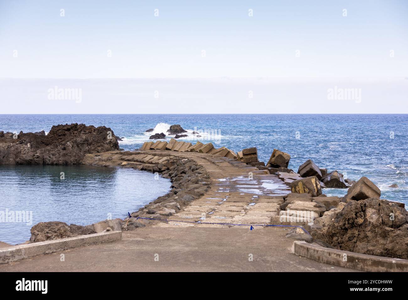 Blick auf den natürlichen Pool und den Atlantischen Ozean, getrennt durch einen Pier in Seixal. Insel Madeira, Portugal Stockfoto