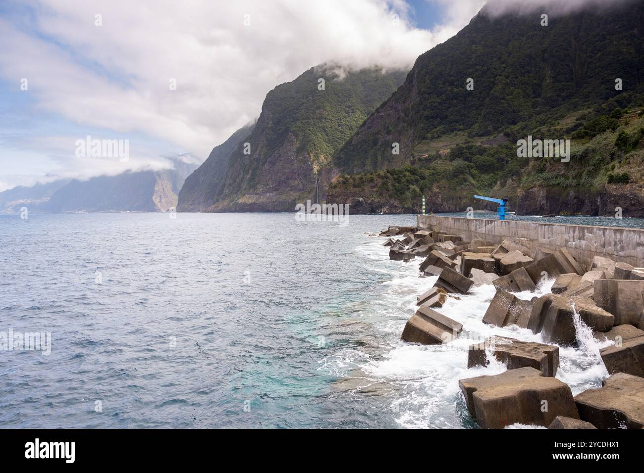 Die Küste von Seixal mit großen Klippen und der Hafen mit dem Wasserfall Véu da Noiva im Hintergrund. Insel Madeira, Portugal Stockfoto